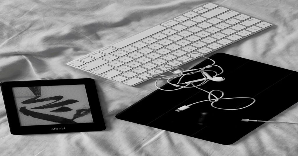 Digital minimalism for solo travelers gear including a compact multi-port charger and an e-reader on a wooden table