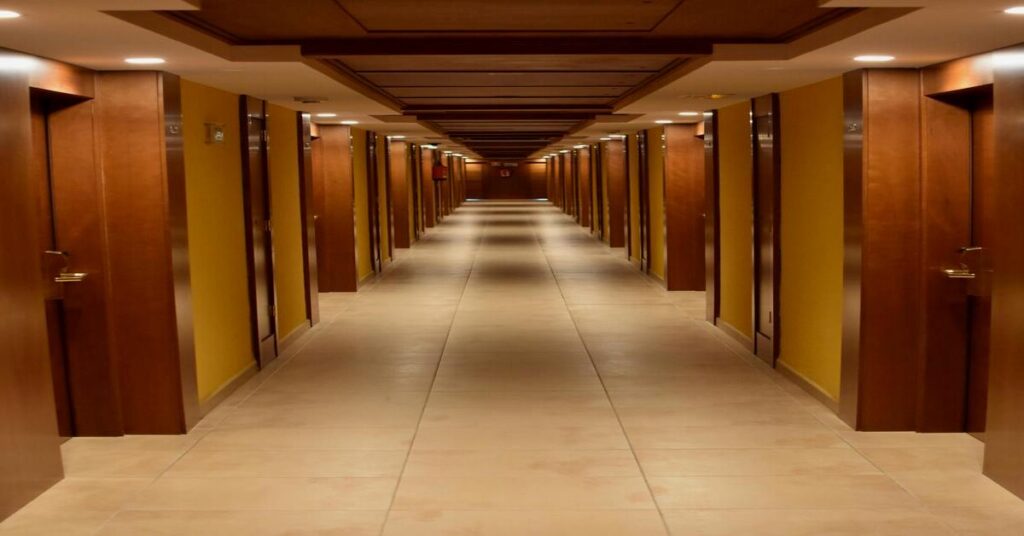 Modern hotel interior corridor hallway with warm lighting and security cameras 1