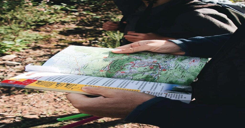 group hiking trail hands holding map nature scenery