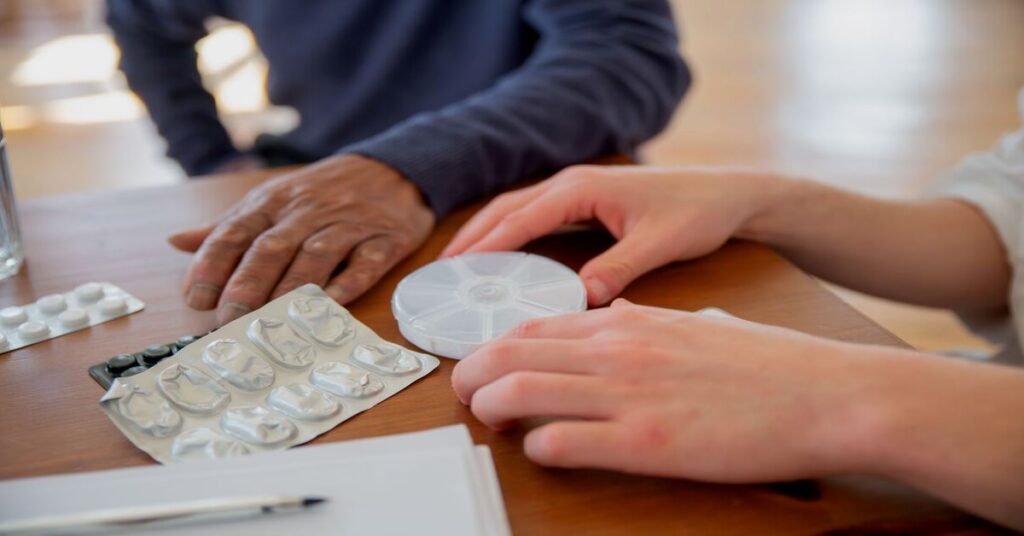travel pill organizer on table beside packing list