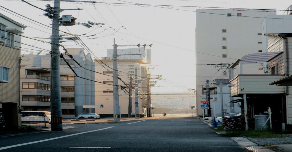 Reverse solo touring on an empty city street at dawn with beautiful morning sunlight hitting the buildings