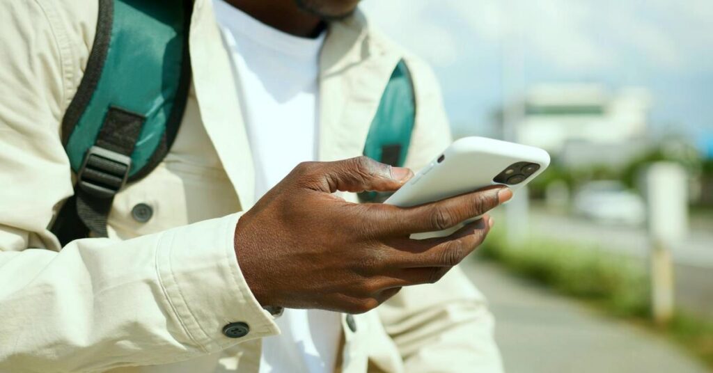 solo traveler using phone airport backpack travel planning