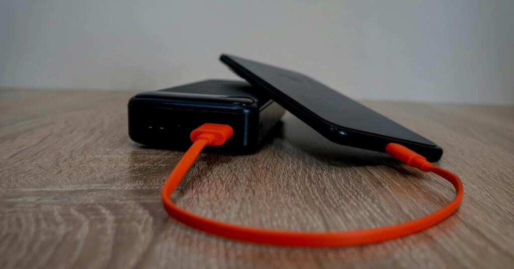 Best power bank for travel charging a mobile phone on an airplane tray table during a safe flight