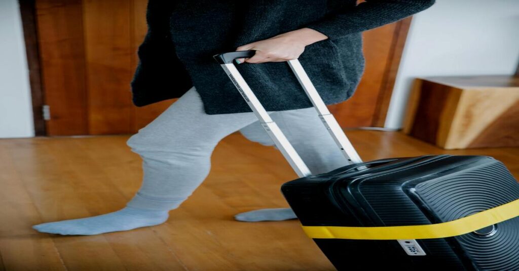 Portable luggage scale for air travel displayed on a packed suitcase