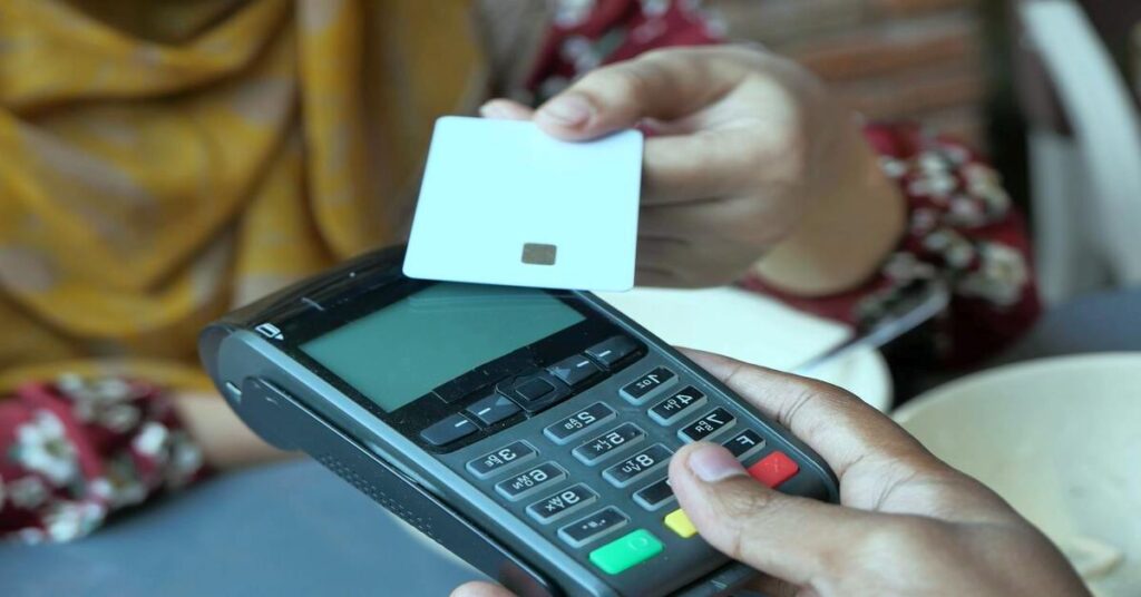 Contactless payment credit card reader machine close up hand