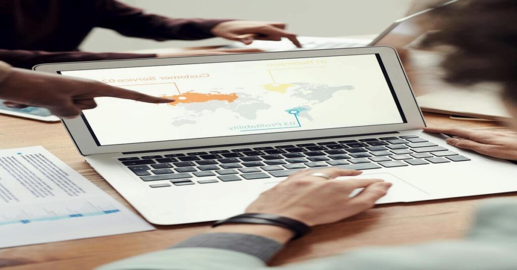 Laptop displaying colorful world map flight routes on rustic table