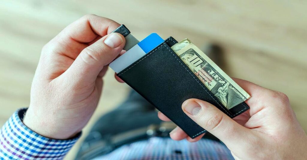 Minimalist slim wallet cash in hands close up