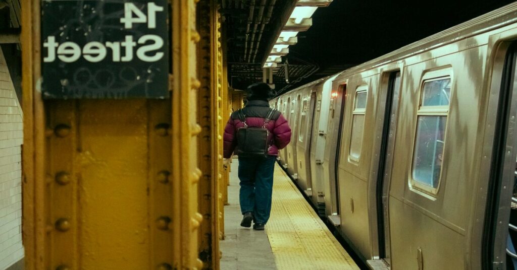Passenger carrying backpack waiting public transit platform train station