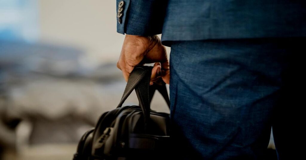 Best Travel Backpack for Organization: Top 7 Picks (2026) 5 Professional business traveler carrying clean organized backpack through high end corporate office 2