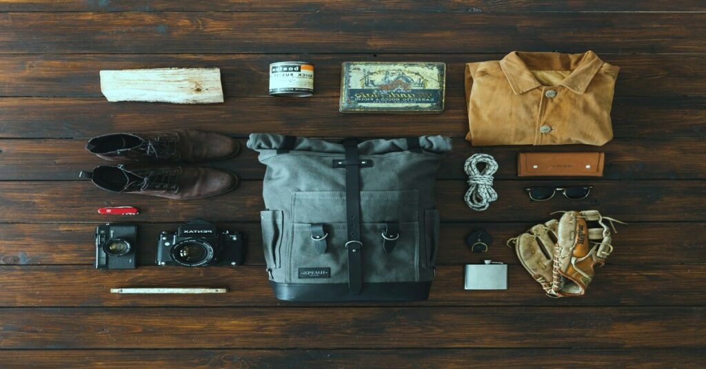 Solo Travel Packing Checklist essentials featuring a tactical carry-on backpack and gear on a rustic wooden floor