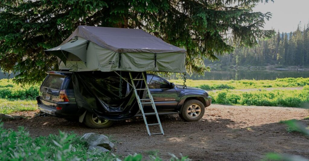 car camping vehicle setup rooftop tent woods forest campsite safety