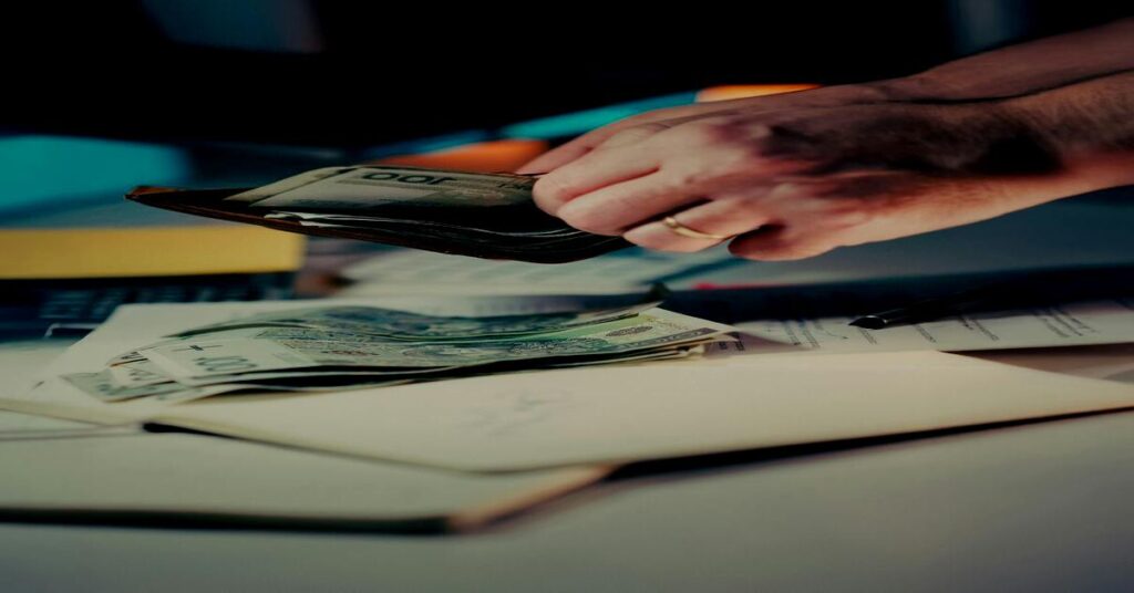 hands counting travel money bills wallet table