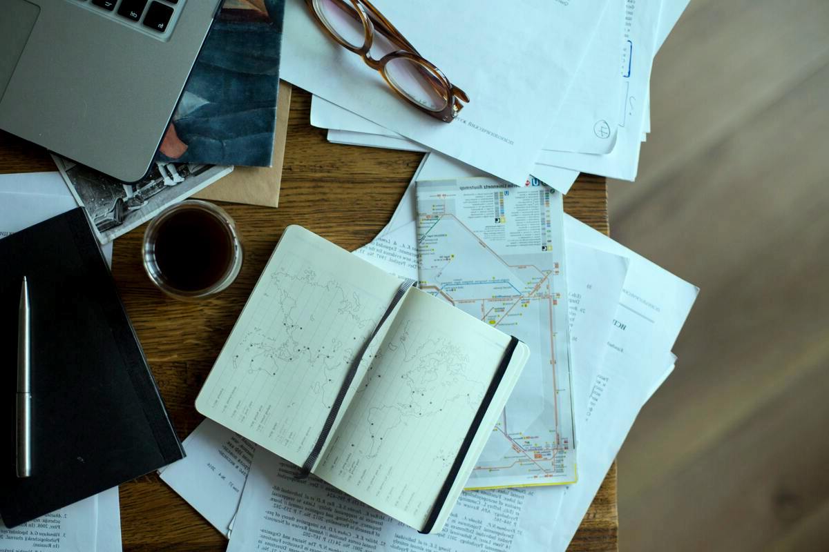 Disclaimer travel content planning accuracy concept with maps laptop and notes for informed decisions