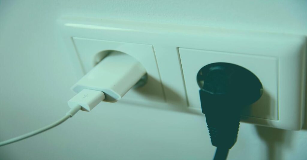 International Travel Plug Adapter Guide traveler struggling to charge phone in foreign hotel socket