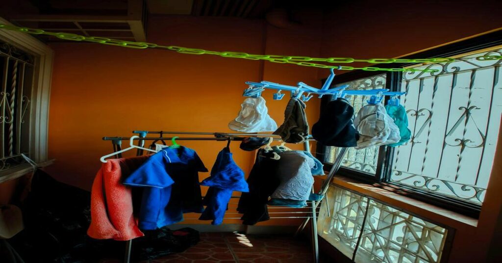 Best Travel Clothesline for Hostel Laundry setup hanging wet clothes inside a backpacker dorm room