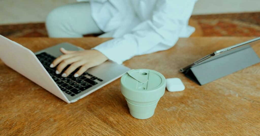 Silicone travel kettle boiling hot water beside a digital nomad laptop warm aesthetic travel vibe
