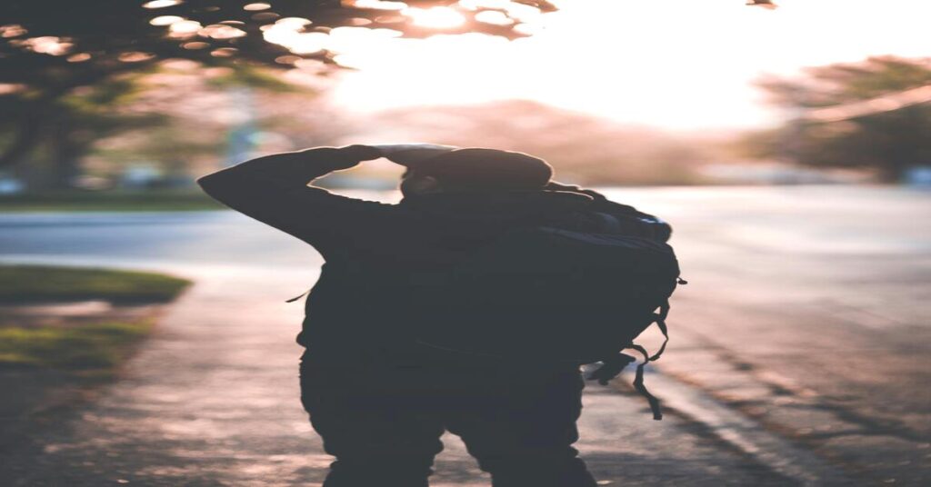Night vs Day Solo Travel Safety dynamics shown via a lone traveler carrying luggage down an urban street