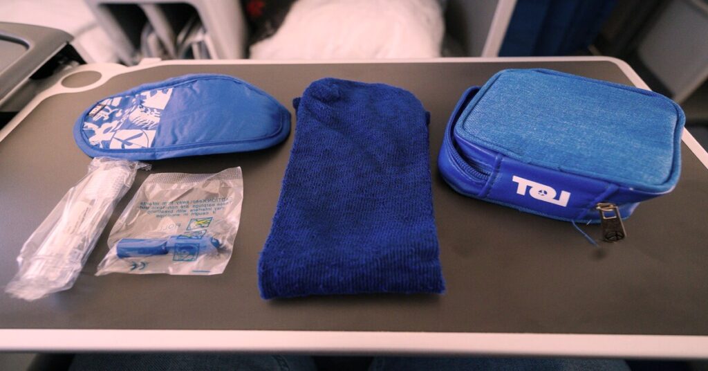 Best sleep mask for travel items laid out flat on a bed for overnight flight preparation