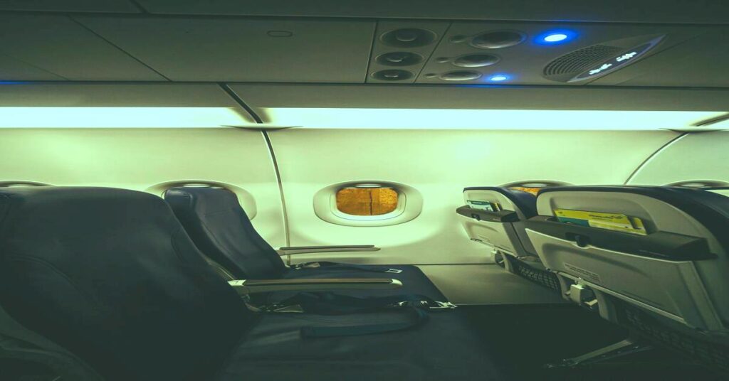 bright airplane cabin lights empty seats night travel lighting no people