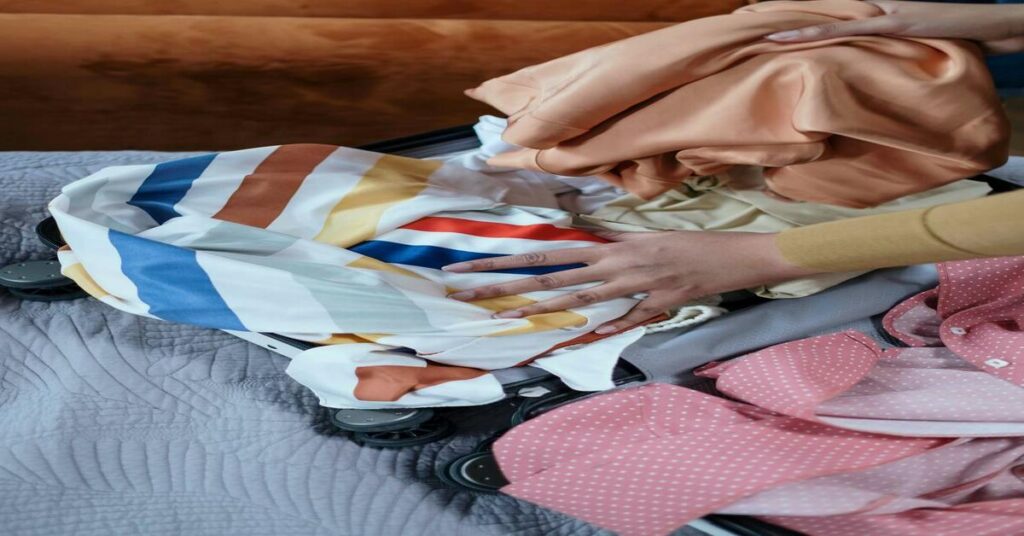 wrinkled clothes on bed travel unpacking suitcase clothes messy