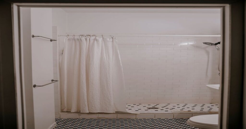 Empty modern communal shower stall bathroom with wet tiles and no shelves