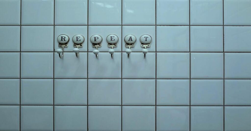 Metal bathroom hooks hanging over door frame close up view