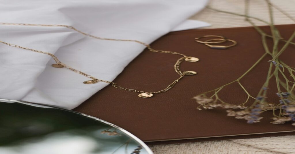 gold necklace flatlay aesthetic travel gear