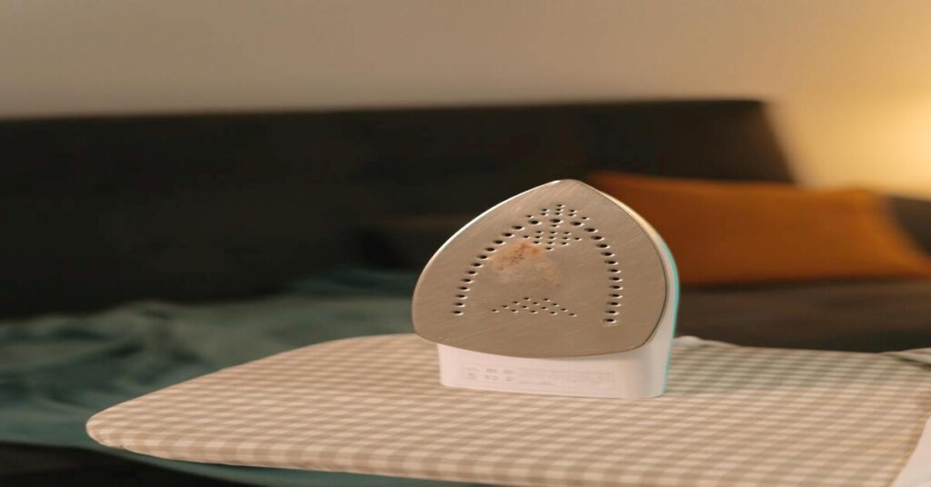 Best Portable Travel Clothes Steamer Dual Voltage: Top 3 Picks 1 ironing board messy hostel laundry room background